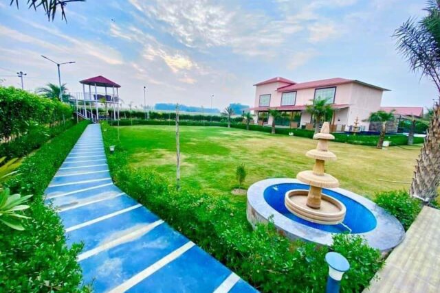 Sector 135 Noida A luxurious farmhouse with a fountain and manicured lawn in Sector 135, Noida.