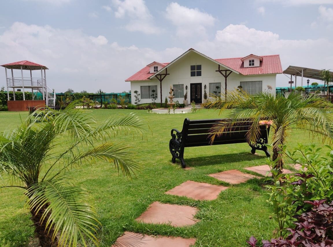 Farmhouses in Noida and NCR. A luxurious farmhouse with a fountain and manicured lawn in Sector 135, Noida.